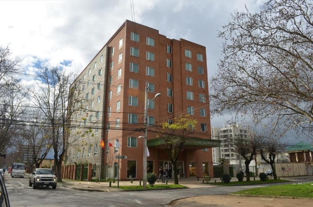 un grand bâtiment en briques rouges sur une rue de la ville dans l'établissement Hotel Diego De Almagro Talca, à Talca