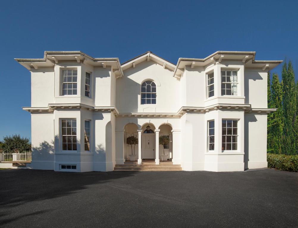 a large white house with a driveway at The Manor in Torquay