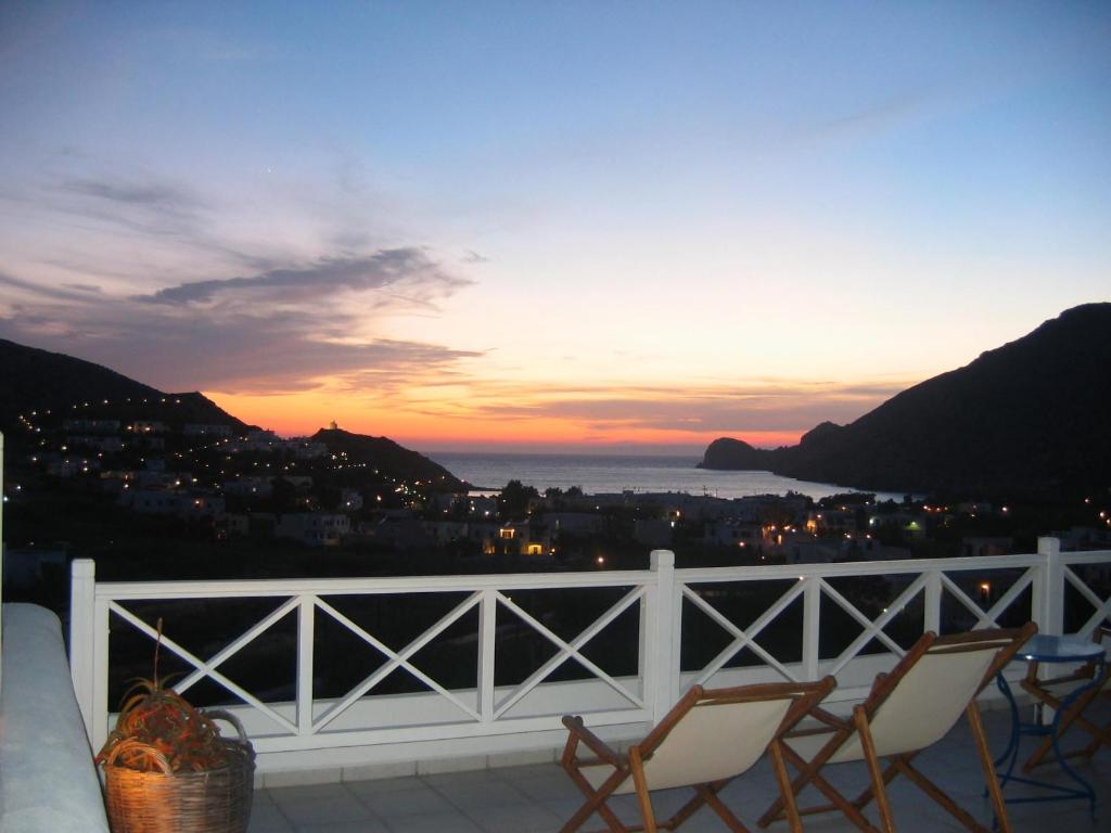 een balkon met stoelen en uitzicht op de zonsondergang bij Korali apartments in Galissas