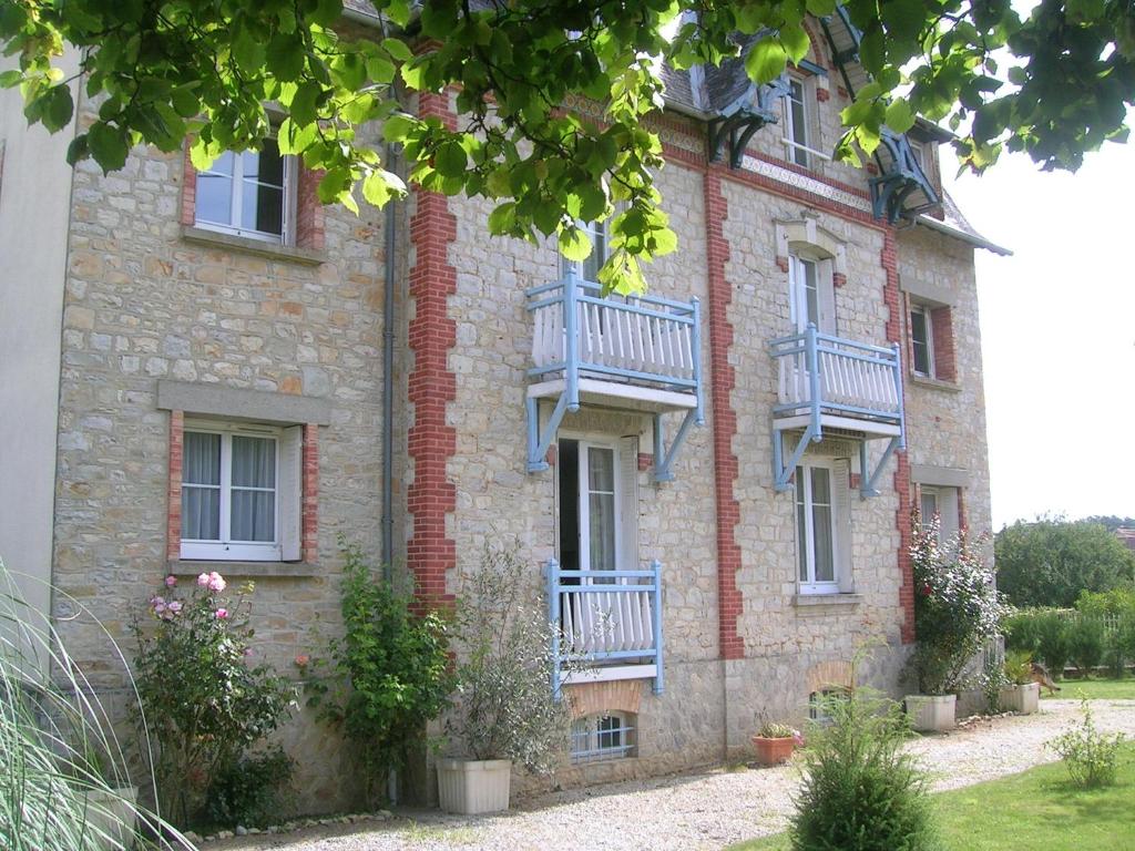 - un bâtiment en briques avec des balcons sur le côté dans l'établissement Appartements Villa Odette, à Bagnoles-de-l'Orne