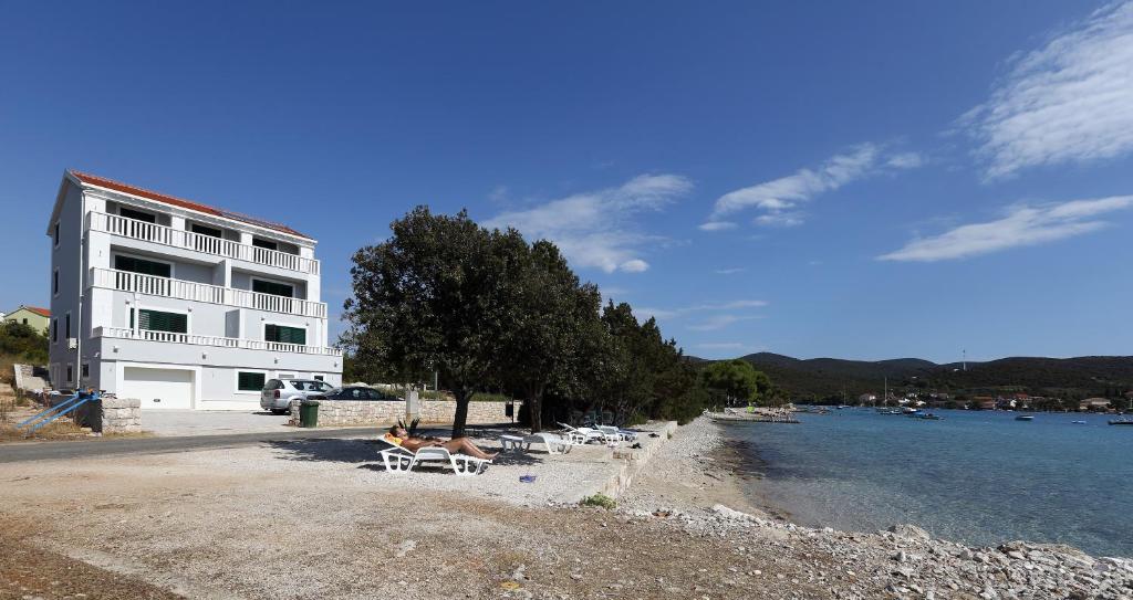 een strand met stoelen en een gebouw naast het water bij Villa Marijola in Lovište
