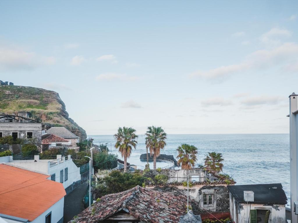 uma cidade com palmeiras e o oceano em Nature Madeira Guest House em Porto da Cruz