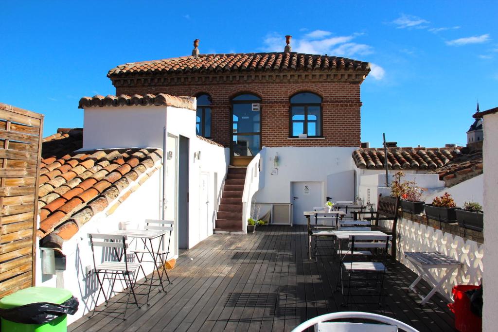- un balcon d'une maison avec des tables et des chaises dans l'établissement Oasis Backpackers' Toledo, à Tolède