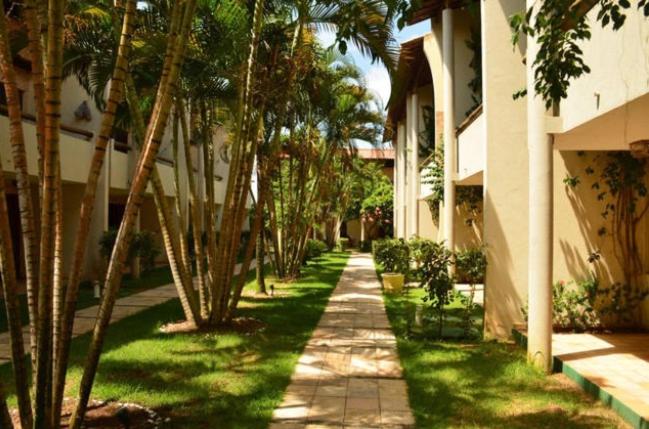 a walkway with palm trees in front of a building at Solar Pipa 195 in Pipa