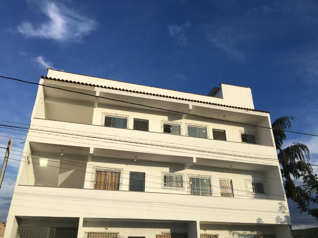 a white building with a blue sky in the background at Stay in Itatiaia in Itatiaia