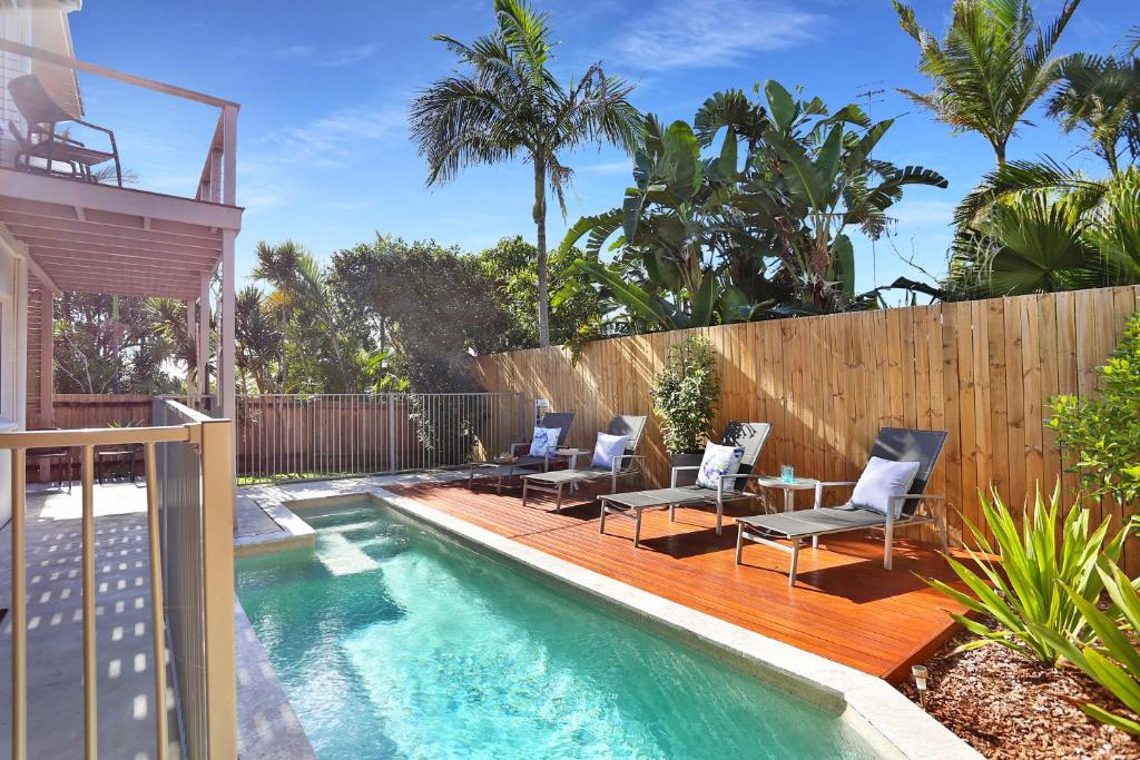 un patio trasero con una piscina con sillas y una valla en Casa del Sol, en Sunrise Beach