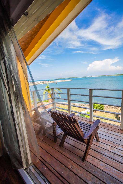 a bench on a deck with a view of the beach at Summer Ya B&amp;B in Huxi