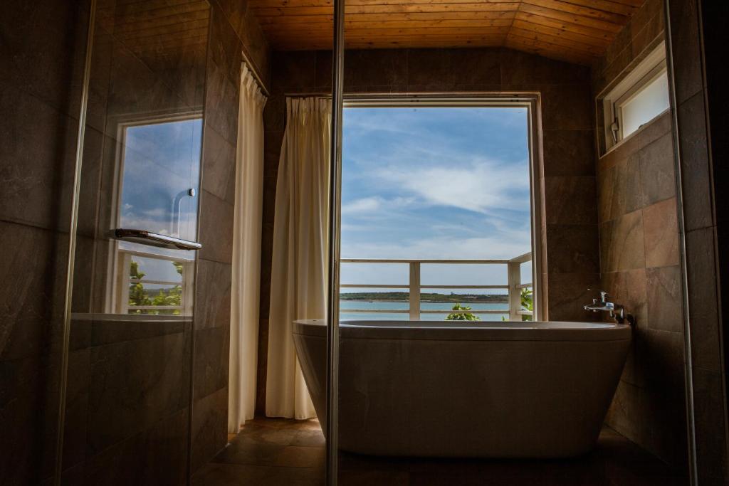 a bathroom with a tub with a view of the ocean at Summer Ya B&amp;B in Huxi