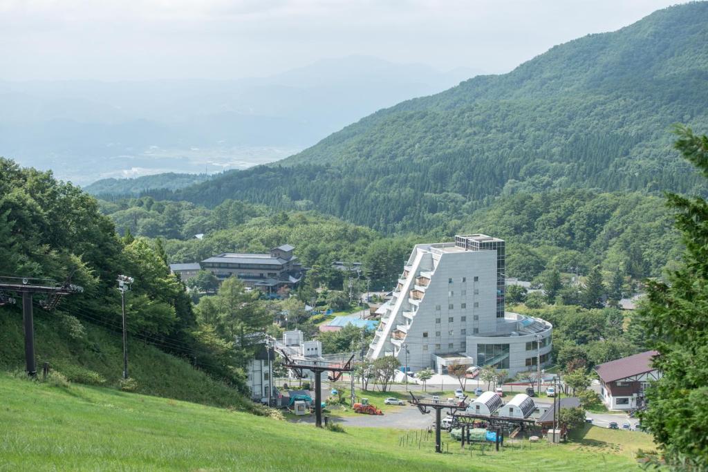 a view of a town with a mountain at Takamiya Hotel Rurikura Resort in Zaō Onsen