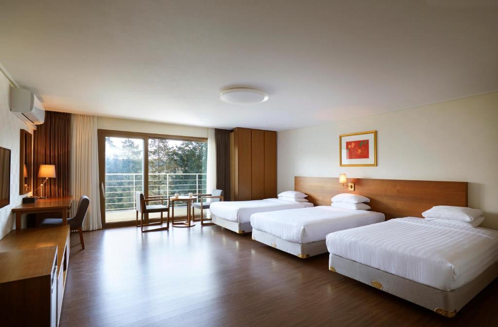Postel nebo postele na pokoji v ubytování Jeju Aerospace Hotel