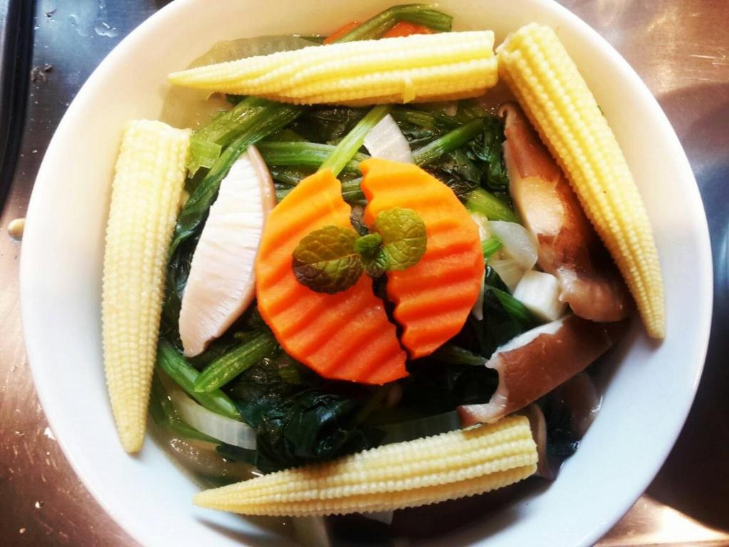 a plate of food with vegetables and corn on a table at Park 61 in Luodong