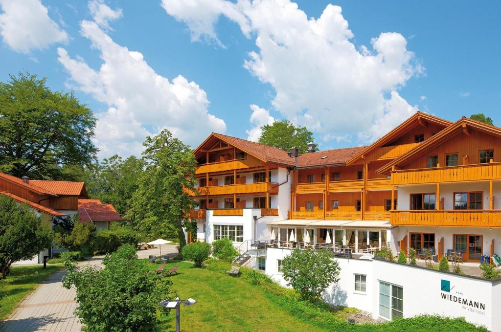 - un grand bâtiment avec des tons orange et blanc dans l'établissement Vital Hotel Wiedemann, à Füssen