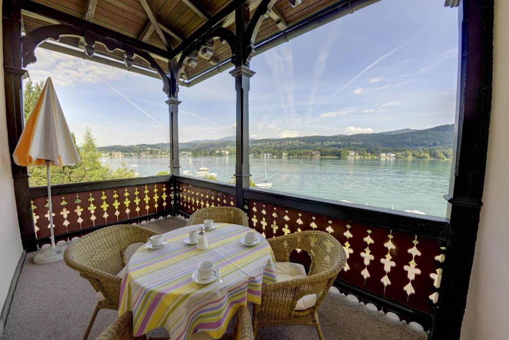 una mesa en un balcón con vistas al agua en Seeappartements Bundschuh, en Velden am Wörthersee