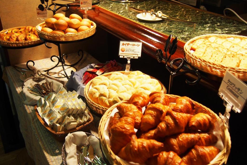 a display of bread and pastries in baskets on a table at New Otani Inn Tokyo in Tokyo