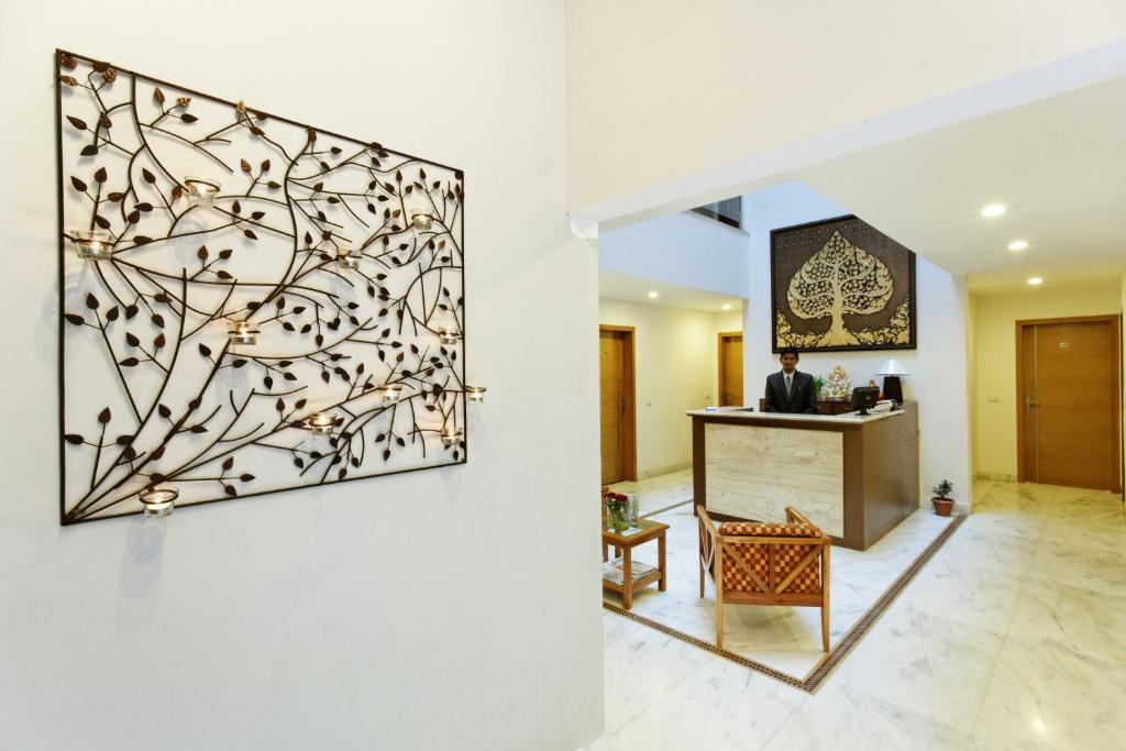 a man standing at a reception desk in a lobby at Silver Oak in Gurgaon