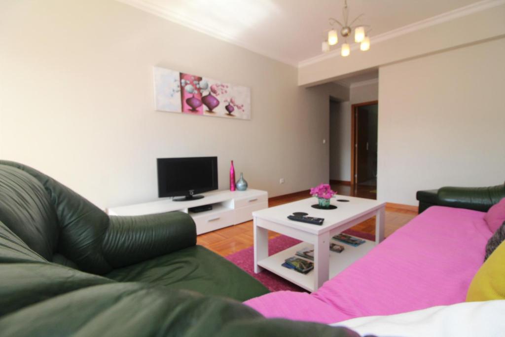 a living room with a couch and a tv at Apartamento Orquidea in Funchal