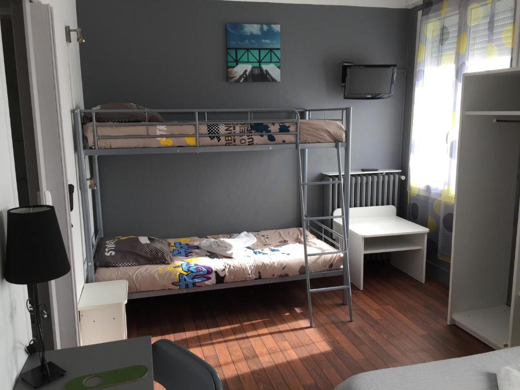 a bedroom with two bunk beds and a desk at Crystal Hotel in Royan