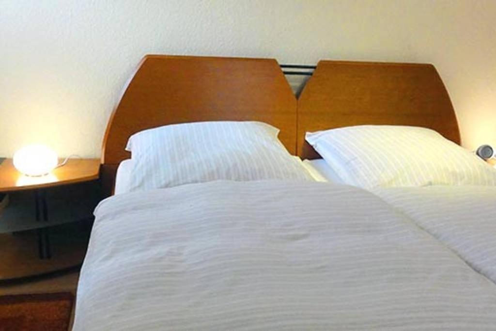 a bedroom with a large white bed with a wooden headboard at Haus Harmonie in Bad Driburg