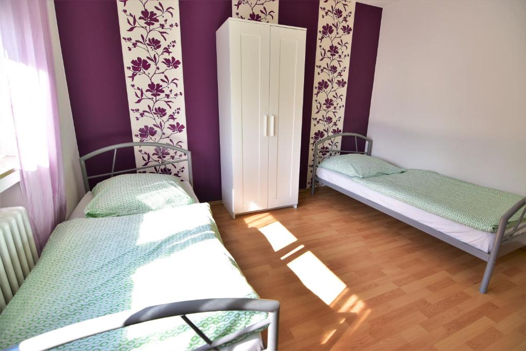 2 camas en una habitación con paredes moradas en Work & Stay Sankt Augustin mit Dachterasse en Sankt Augustin