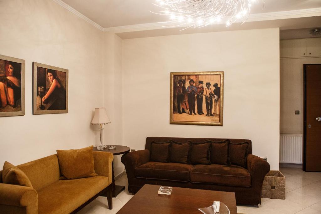 a living room with couches and paintings on the wall at Melon Suites in Thessaloniki