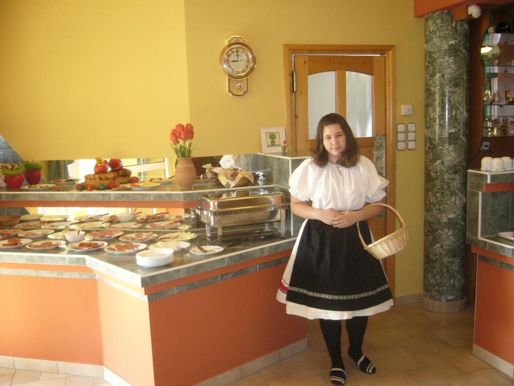 kobieta stojąca przed ladą w kuchni w obiekcie Erika Pension w mieście Keszthely