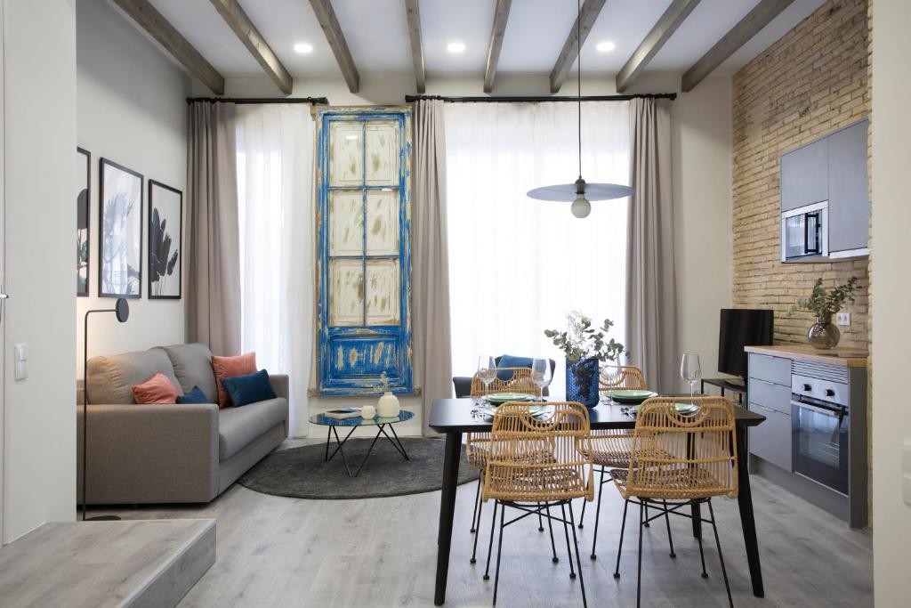 een keuken en een woonkamer met een tafel en stoelen bij SingularStays Parque Central in Valencia