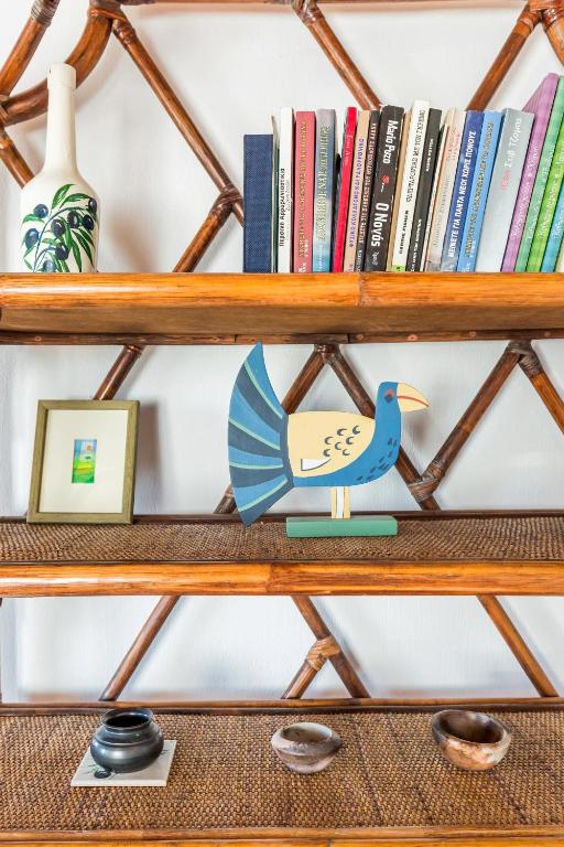 a wooden shelf with books and a blue bird on it at Villa Thea in Panormos Skopelos