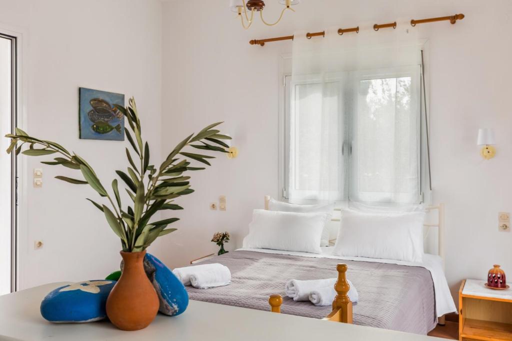 a bedroom with a bed with a vase on a table at Villa Thea in Panormos Skopelos