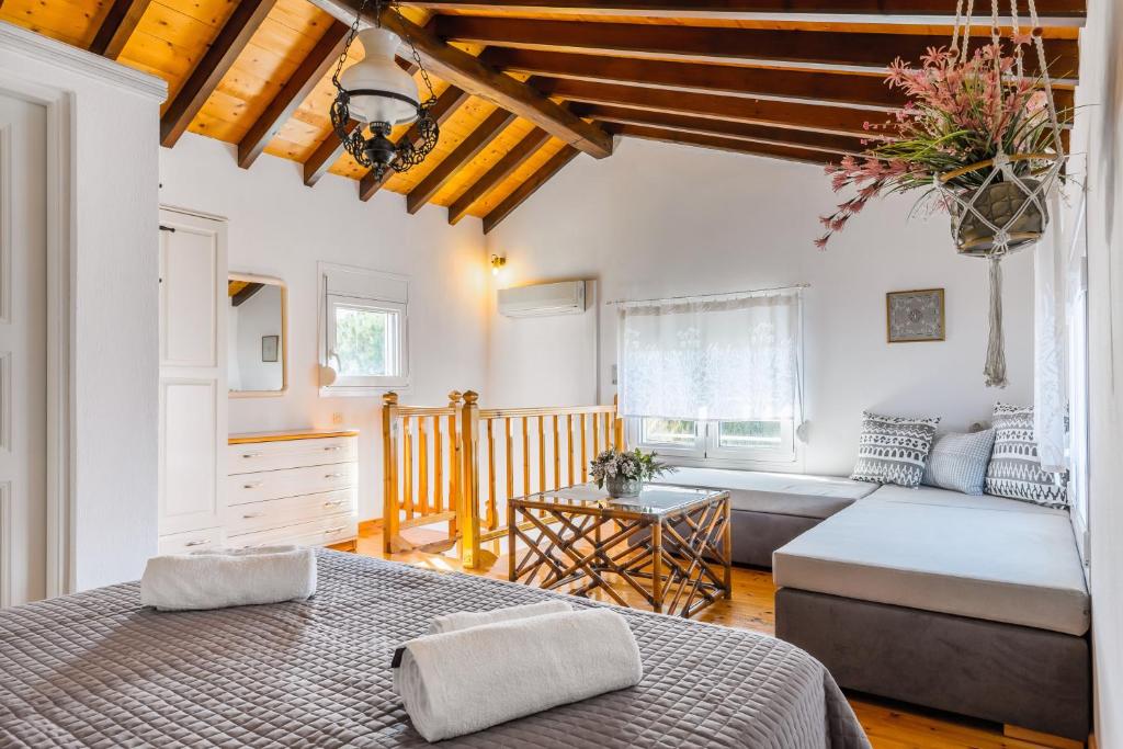 a bedroom with a bed and a couch in a room at Villa Thea in Panormos Skopelos