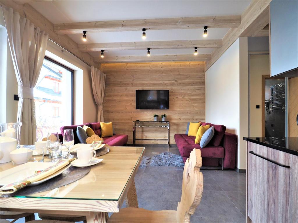 a living room with a couch and a table at VIP APARTAMENTY VILLA GÓRSKIE KLIMATY in Zakopane