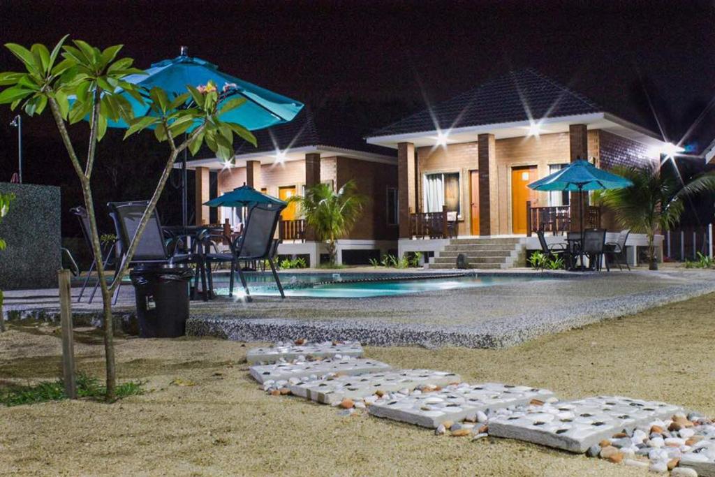 a villa with a swimming pool at night at Casa Tanjung Jara in Dungun