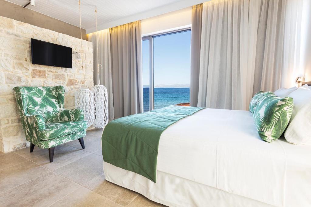 カラマキにあるKalamaki Luxury Suitesのベッドルーム1室(ベッド1台、海の景色を望む窓付)が備わります。
