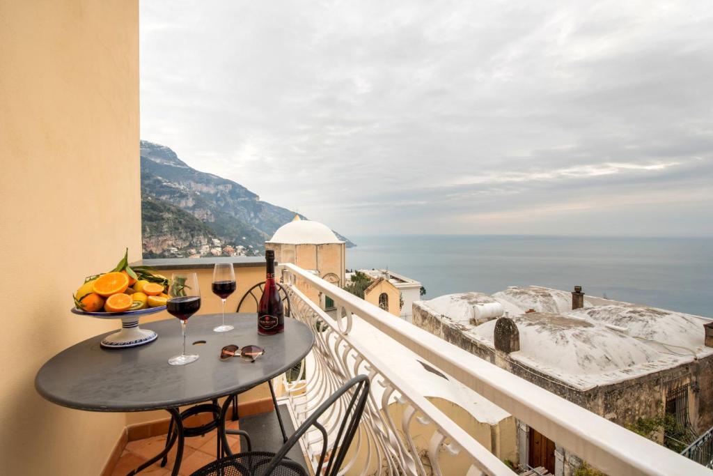 a balcony with a table and a view of the ocean at Ricciolo d'oro 1 in Positano