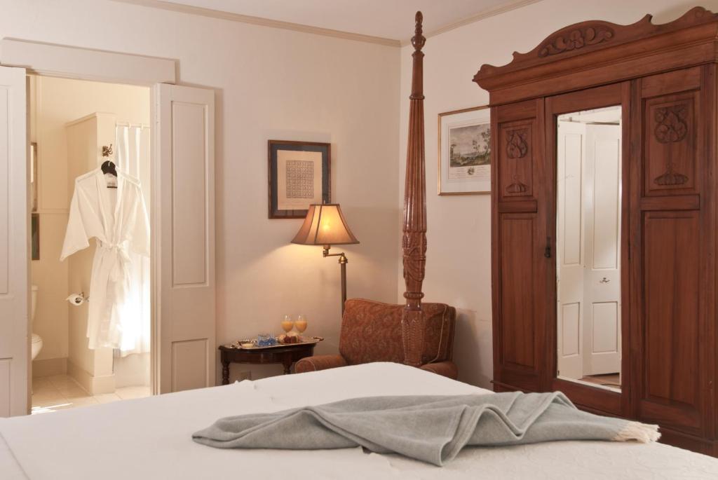 a bedroom with a bed and a dress hanging in a closet at Marshall Slocum Inn in Newport