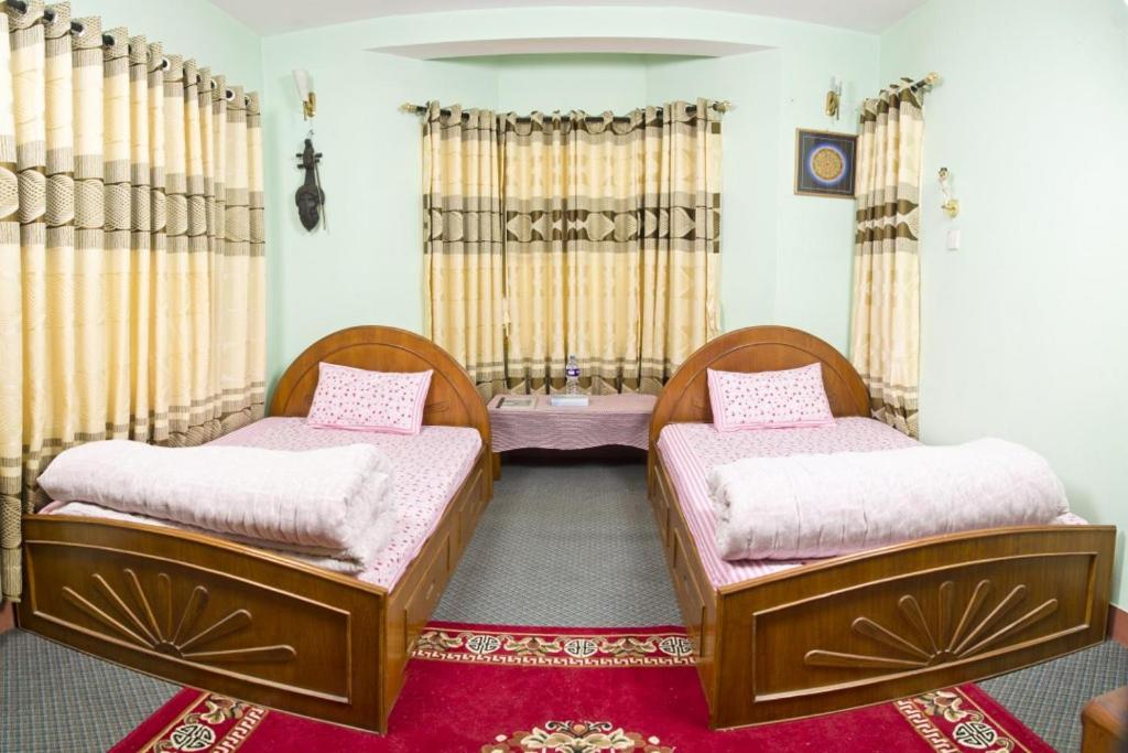 two beds in a room with a red rug at Swagat homestay in Kathmandu