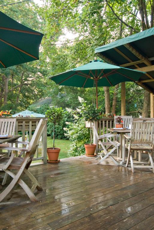 a deck with tables and chairs and umbrellas at Marshall Slocum Inn in Newport