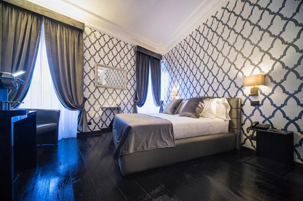 a bedroom with a bed and a wall of windows at Via Veneto Suites in Rome