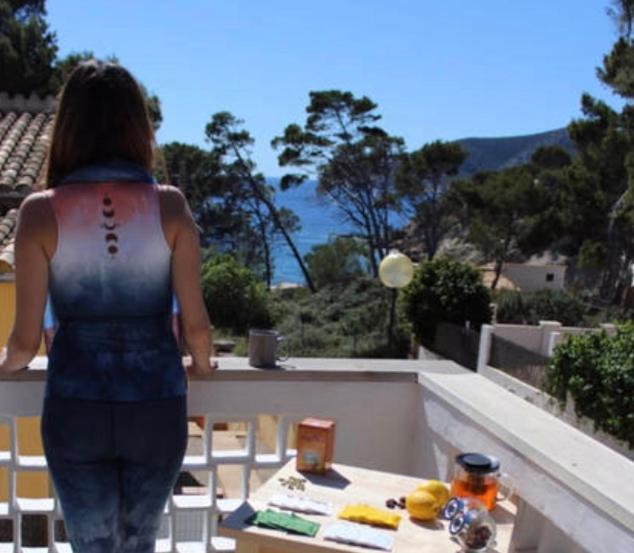 サン・エルムにあるSea House in San Telm, Mallorcaの海を望むバルコニーに立つ女性