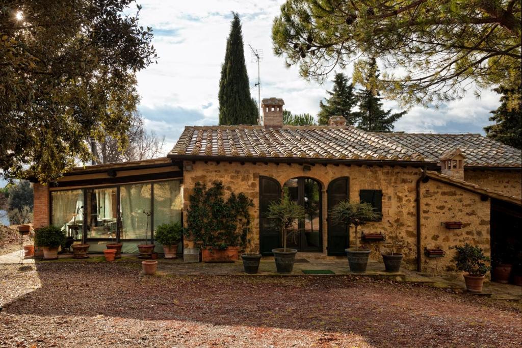 an old stone house with potted plants in front of it at Podere Il Lampo in Montalcino