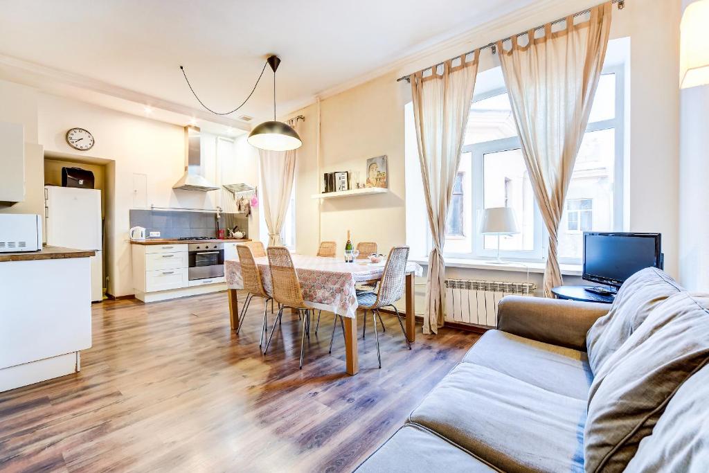 cocina y comedor con mesa y sillas en La Casa Di Bury Apartments 2, en San Petersburgo