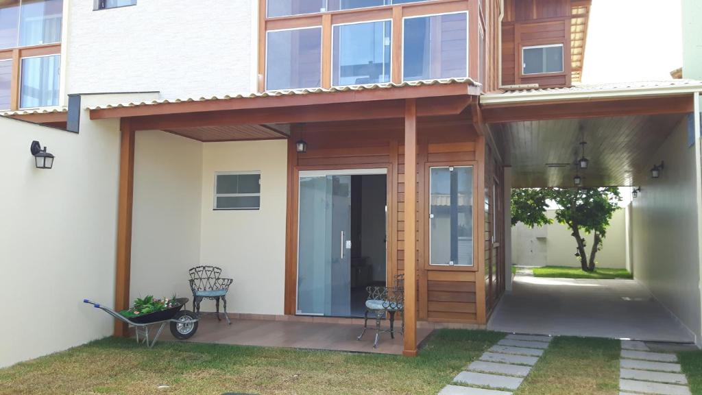 ein Haus mit einer Glastür und einer Terrasse in der Unterkunft Linda Casa 4 Quartos Castelhanos ES in Anchieta