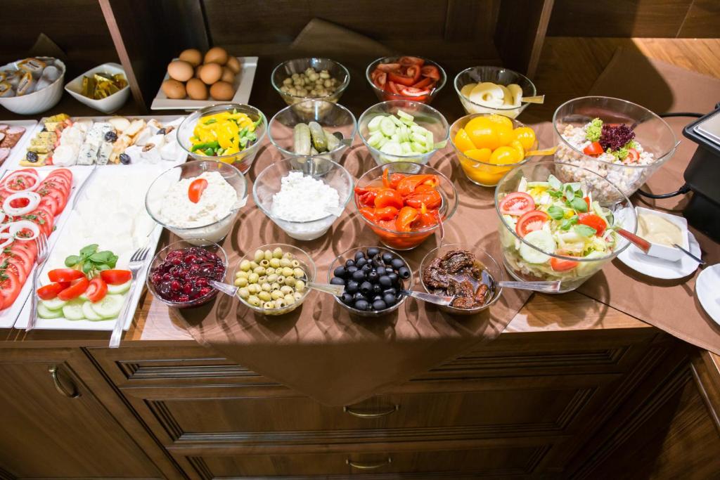 a table with many bowls of different types of food at Hotel Maksymilian in Krakow