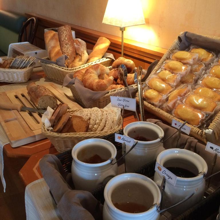 a table with baskets of bread and cups of coffee at Hôtel du Port in Lausanne