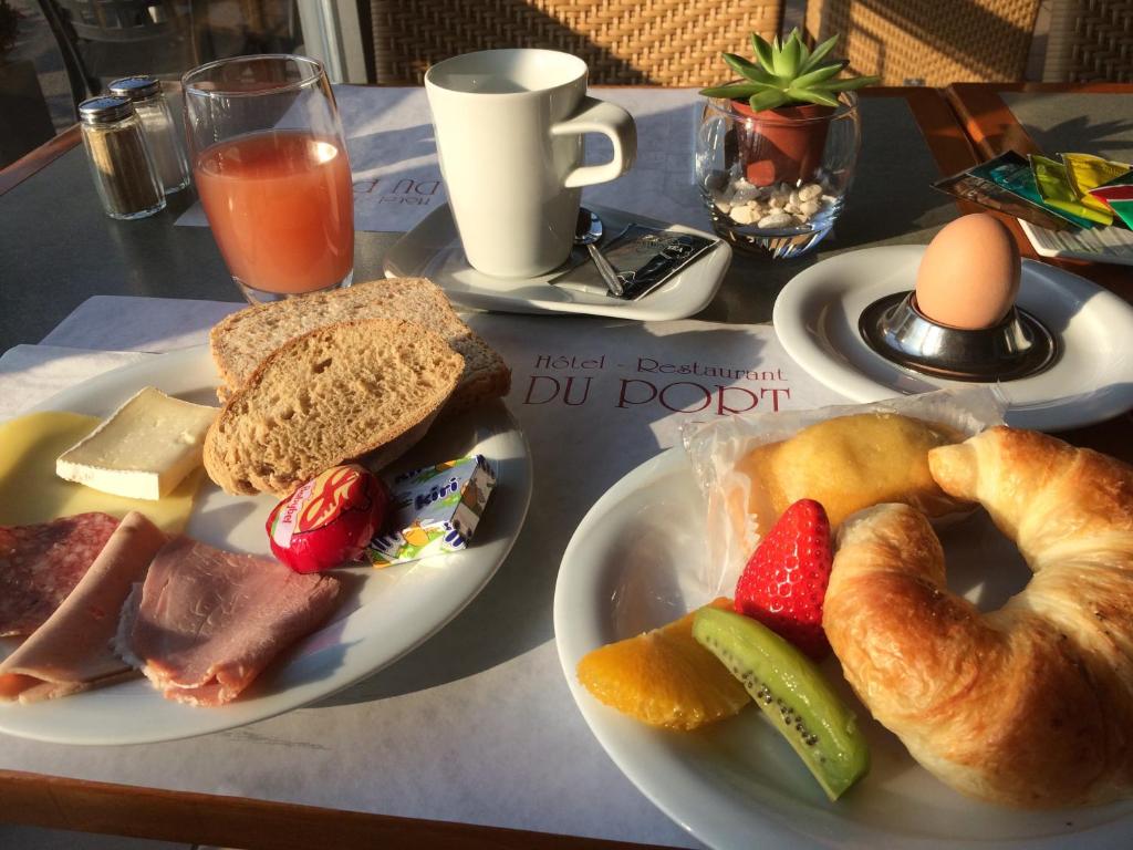 a table with two plates of food with bread and fruit at Hôtel du Port in Lausanne