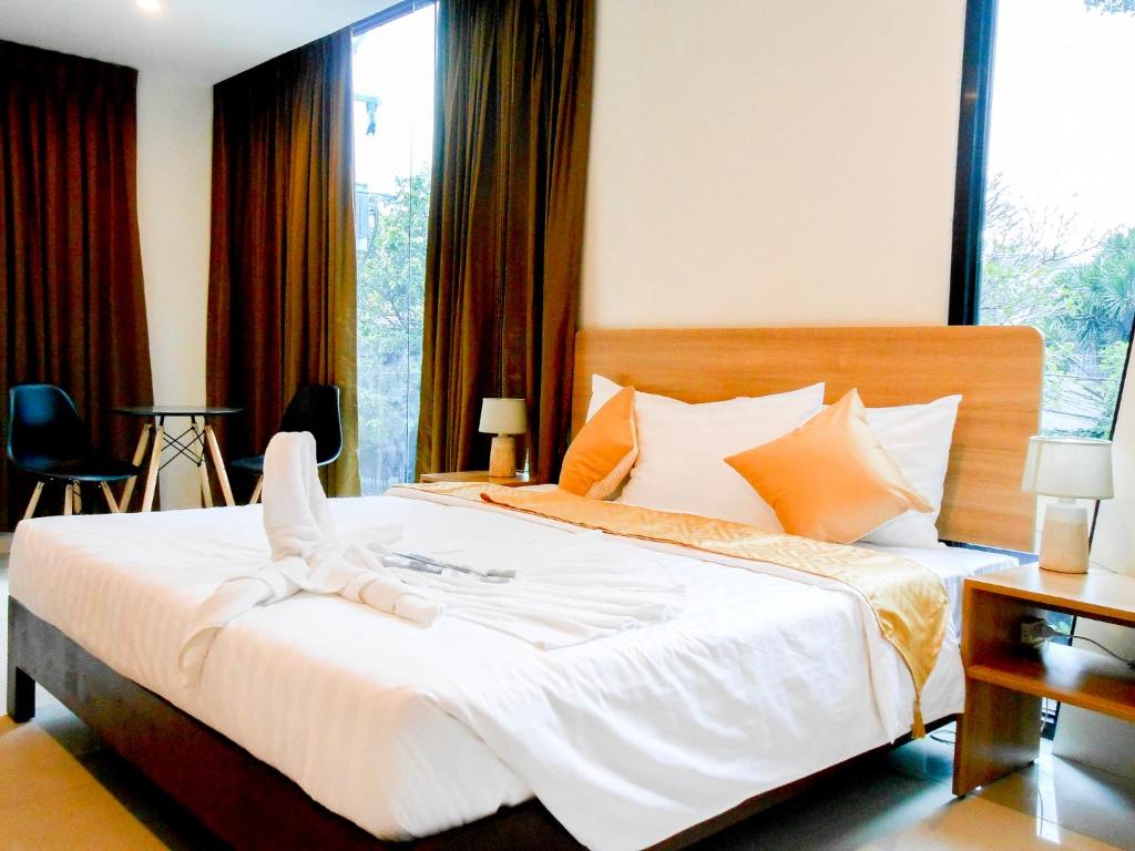 a bedroom with a large white bed with orange pillows at Rublin Hotel Cebu in Cebu City