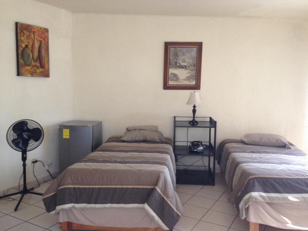 a room with two beds and a fan at Brisas 54632 in Monterrey