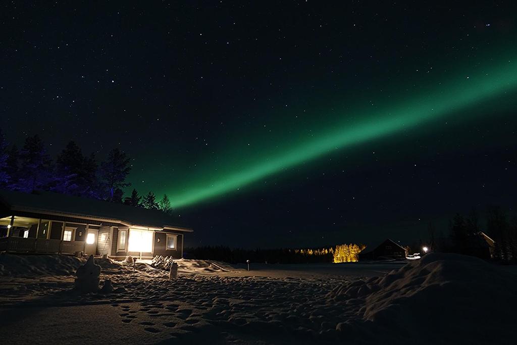 an aurora in the sky over a house at night at Villa Mustikkakumpu in Sonka