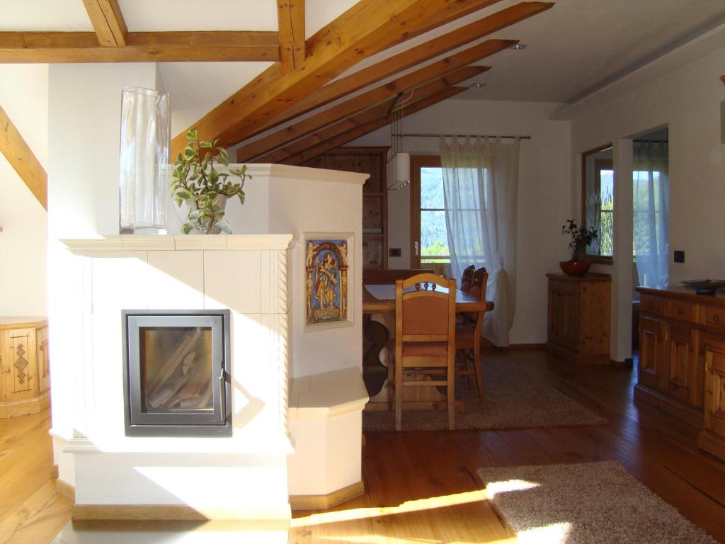 a living room with a fireplace and a table at Fiemme Deluxe Apartment in Castello di Fiemme