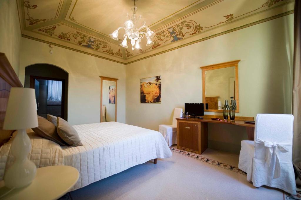 een slaapkamer met een bed, een bureau en een spiegel bij Modà Antica Dimora in San Marino