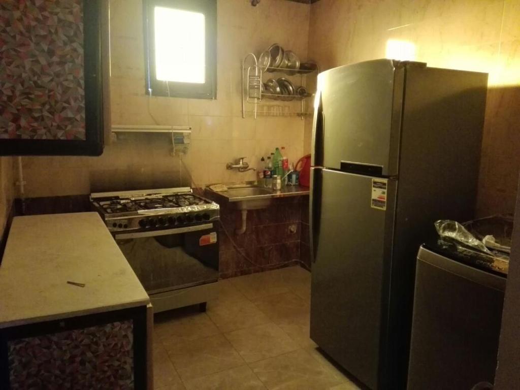 a kitchen with a stainless steel refrigerator and a stove at شمس أسوان شقة شعبية رخيصة أمان in Aswan
